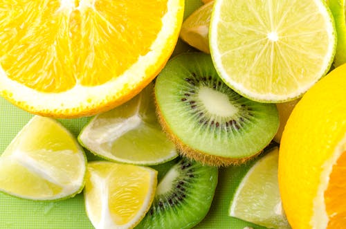 Vibrant close-up of sliced citrus and kiwi fruits showcasing fresh and juicy textures.