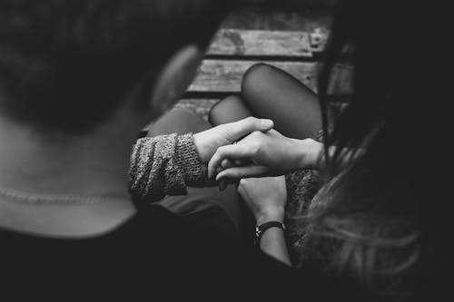 A romantic black and white image of a couple holding hands, symbolizing love and connection.