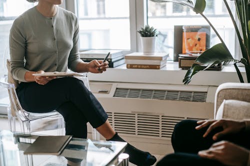 Psychologist consulting a patient in a modern office, emphasizing confidentiality and care.