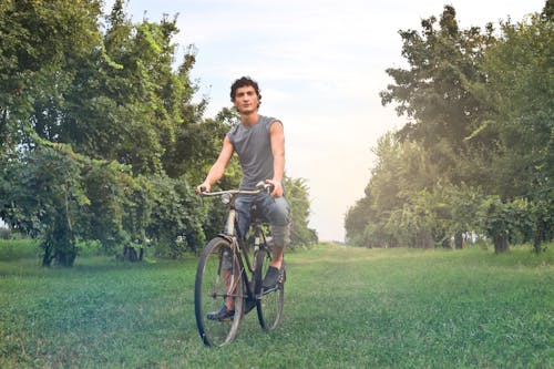 A young man enjoys a bike ride through beautiful green scenery in Calderara di Reno, Italy.